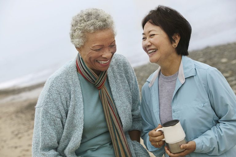 Femmes durant période ménopause souriantes au bord de la mer