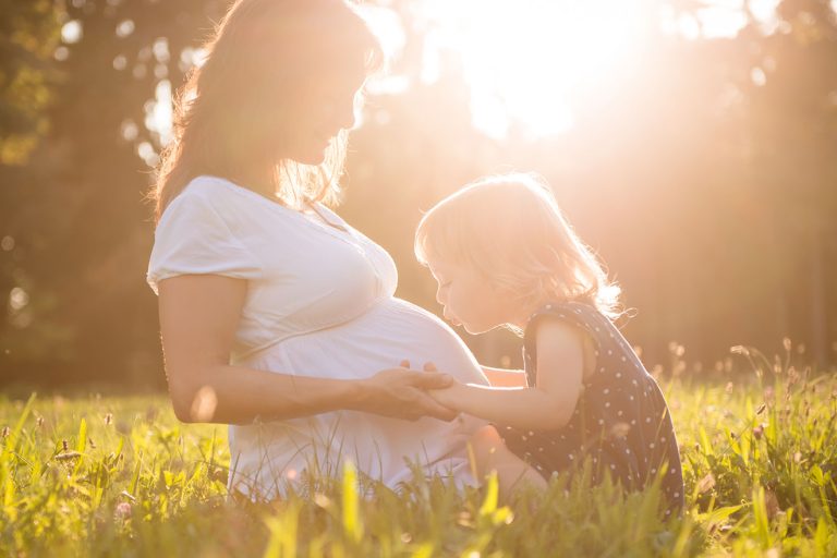 Moment de complicité entre mère et fille avec futur bébé