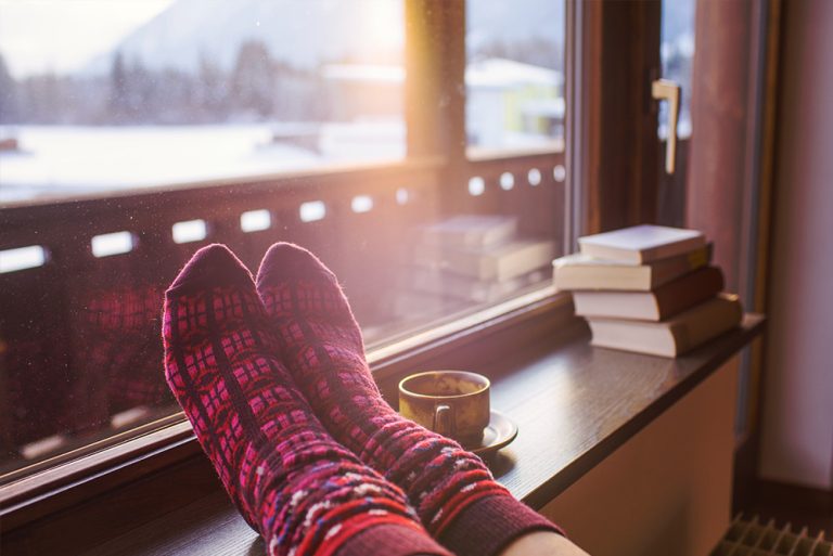 plan rapproché sur les pieds d'une femme avec chaussettes face à la montagne avec neige