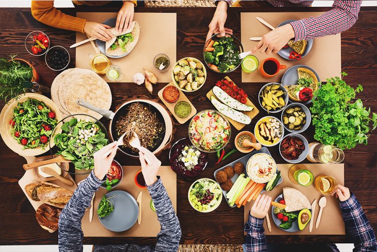 4 personnes à table autour d'un repas vegan - 1000x668