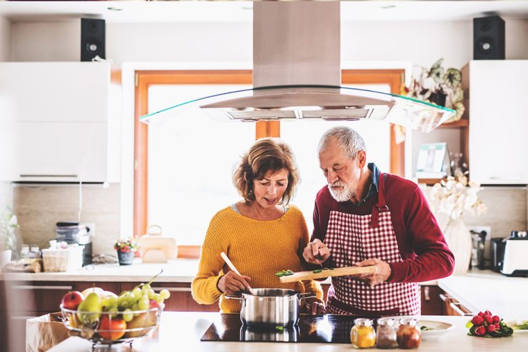 Couple en cuisine préparant des plats avec légumes