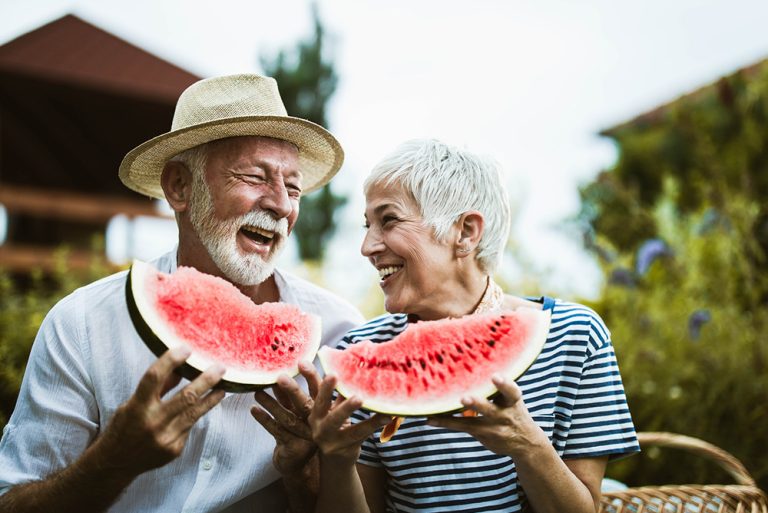 Couple à la retraite heureux dégustant une pastèque