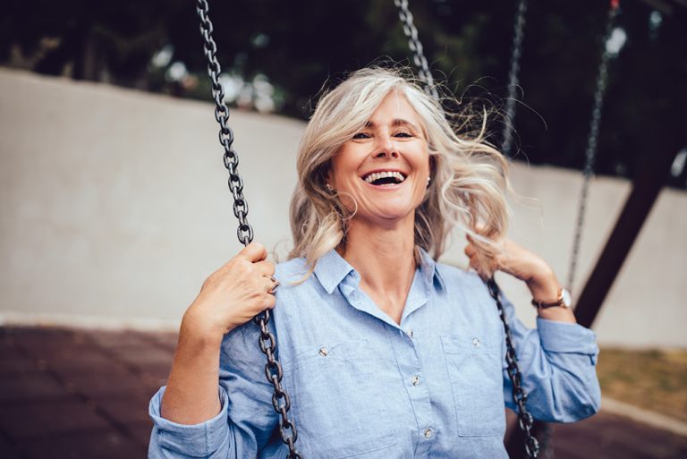 Femme souriante et bien dans son corps sur une balançoire