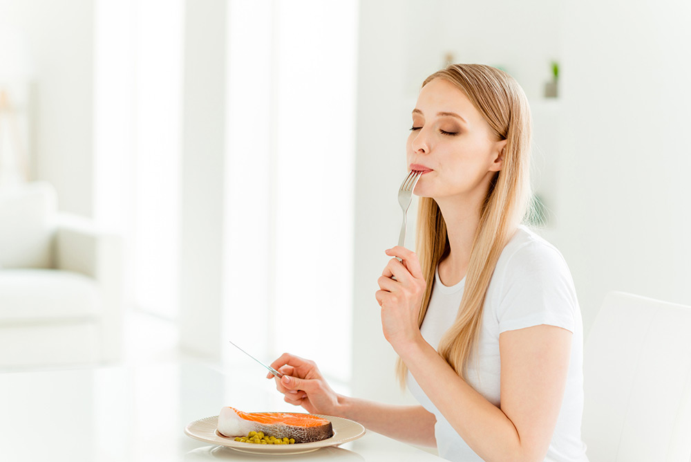 Jeune femme qui savoure un plat sain et équilibré dans la cuisine