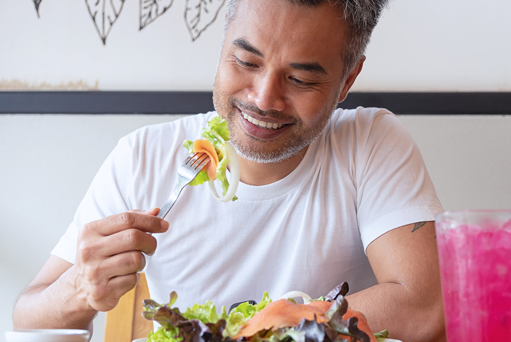 Homme dégustant une salade composée de produits frais