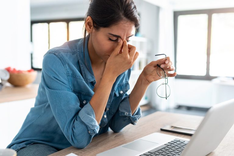 Jeune femme en télétravail devant l'ordinateur stressée et fatiguée