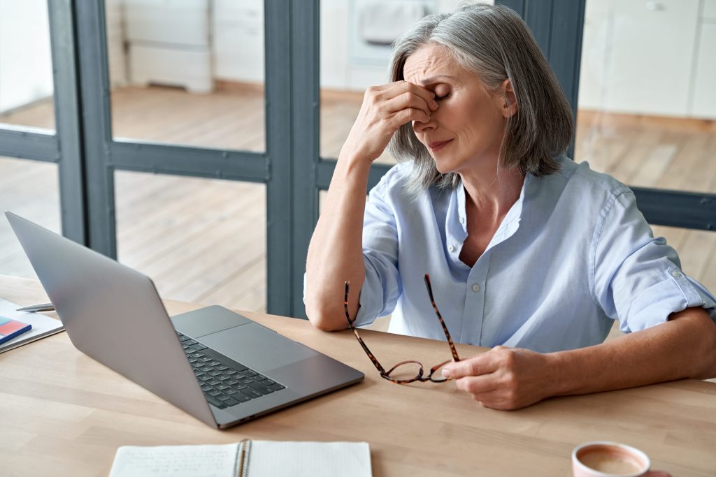 Femme âgée ressentant de la fatigue au travail sur son ordinateur